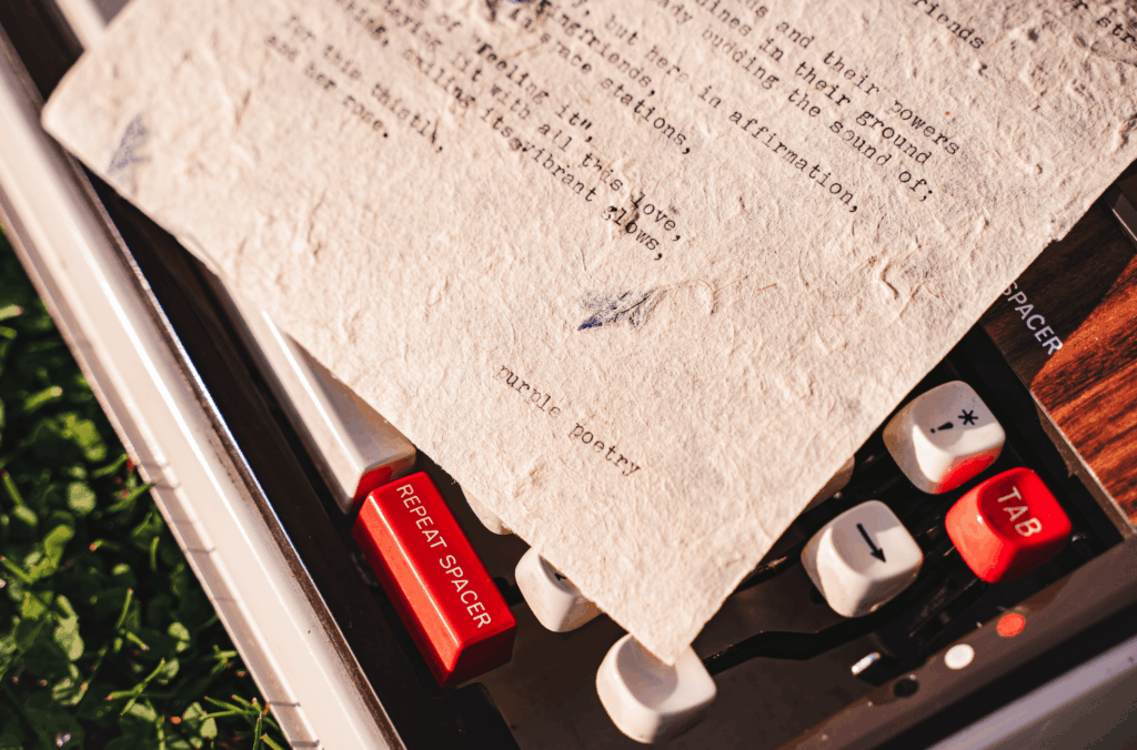 petal paper on a typewriter with words "purple poetry" zoomed in
