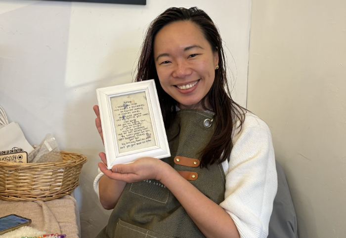 client smiling holding framed custom poem